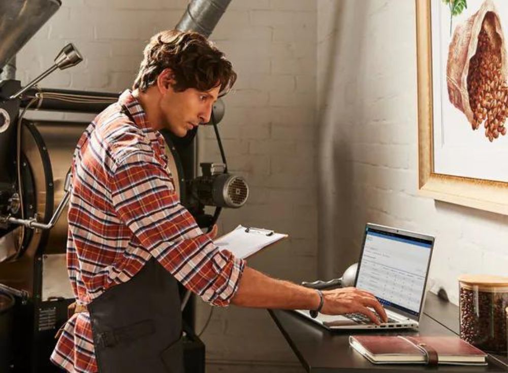 Man using HP laptop in an industrial setting.